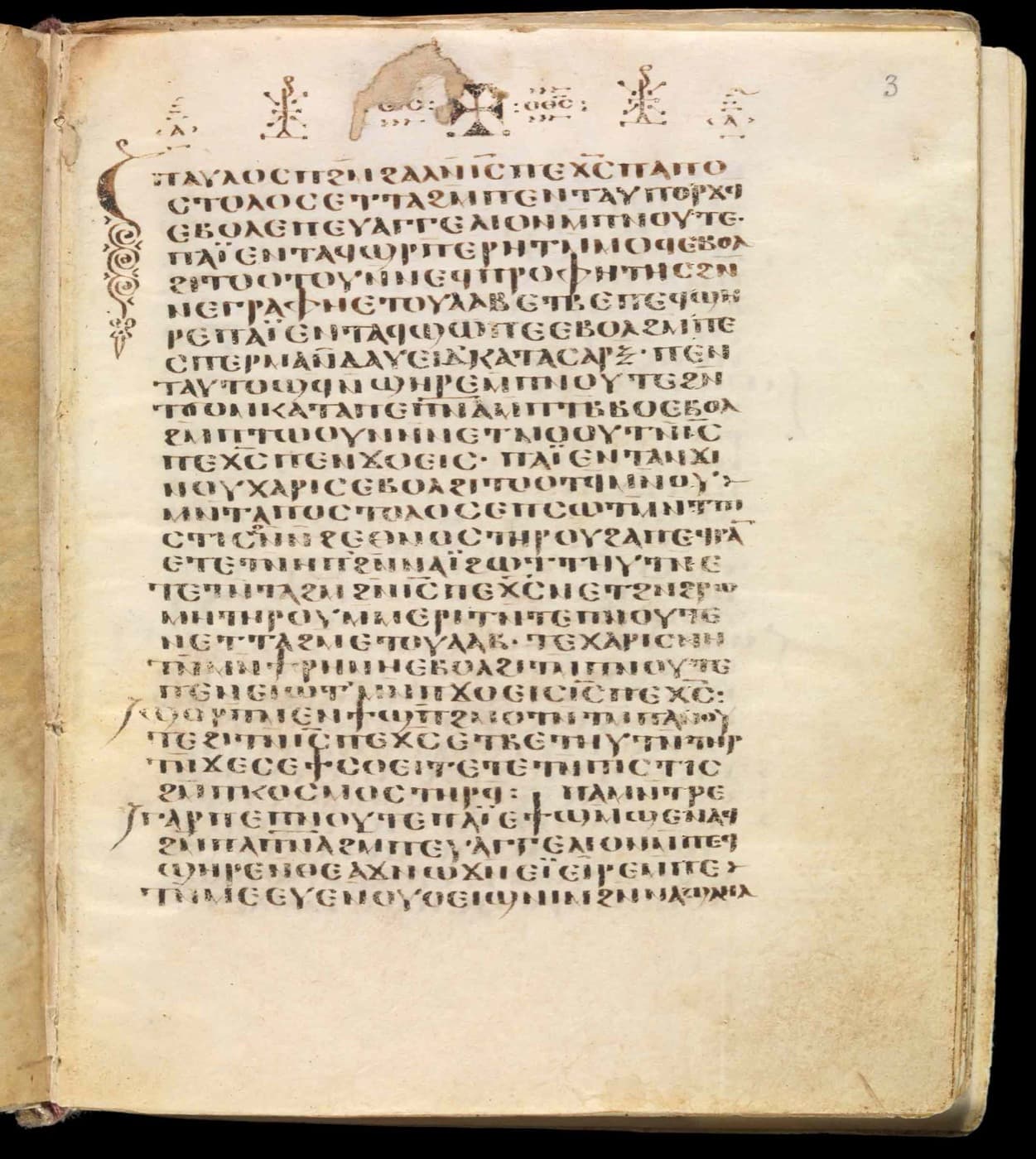 A parchment page of Coptic script with a decorated initial and small crosses at the top