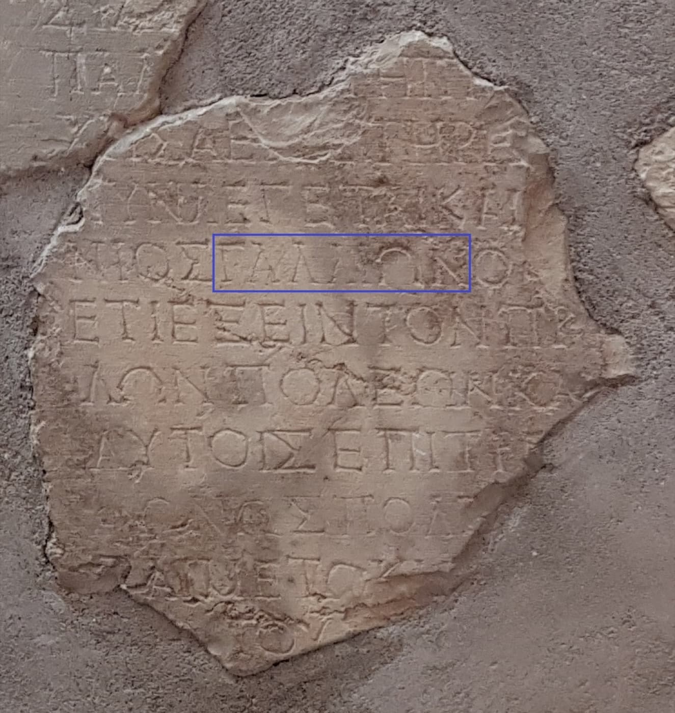 A broken stone slab carved with Greek capitals, with the name Gallio outlined in a box