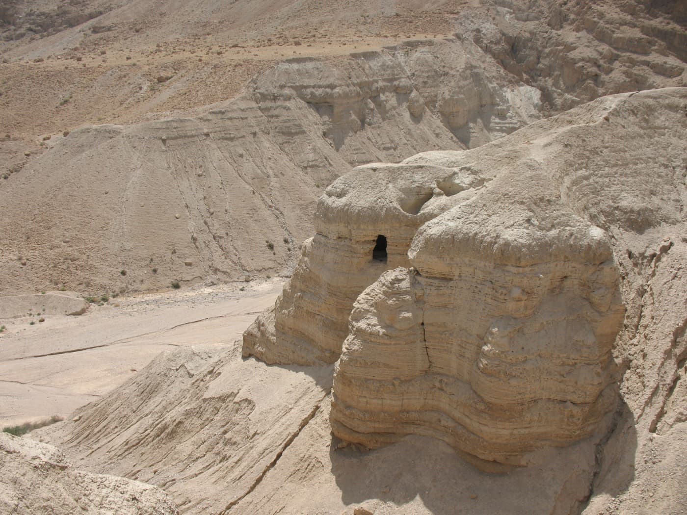 Cave 4 at Qumran, an opening in a pale limestone cliff above a dry ravine near the Dead Sea