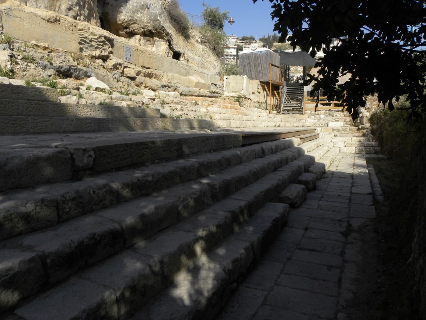 Wide stone steps descending toward a paved area, part of the excavated Pool of Siloam in Jerusalem